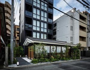 a building on a street with tall buildings at THE HOTELS HAKATA Harushige Honkan in Fukuoka