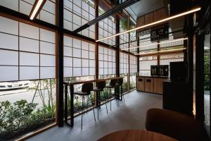 um quarto com janelas grandes e bancos de bar em THE HOTELS HAKATA Harushige Honkan em Fukuoka