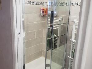 La salle de bains est pourvue d'une douche avec une porte en verre. dans l'établissement Studio Autrans-Méaudre en Vercors-Autrans, 1 pièce, 4 personnes - FR-1-737-8, à Autrans