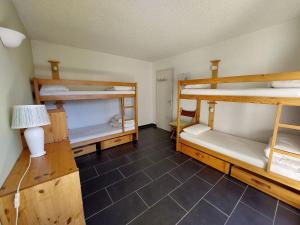 a room with three bunk beds and a lamp at Appartement cosy 3 étoiles, 8 pers, 53 m², proche centre et pistes, balcon sud/ouest, parking privé - FR-1-737-13 in Autrans