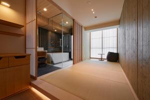 THE HOTELS HAKATA Harushige Honkan في فوكوكا: حمام مع حوض استحمام و نافذة كبيرة