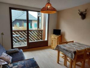 a living room with a table and a view of a balcony at Appartement Autrans, 2 pièces, 4 personnes - FR-1-737-19 in Autrans