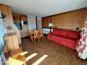 a living room with a red couch and a kitchen at Appartement Autrans-Méaudre en Vercors-Autrans, 2 pièces, 4 personnes - FR-1-737-24 in Autrans