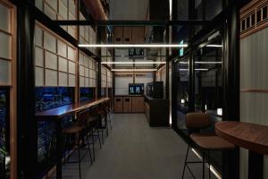 THE HOTELS HAKATA Harushige Honkan في فوكوكا: بار يوجد به كراسي وطاولات في الغرفة