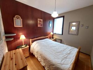 a bedroom with a bed and a wooden wall at Maison mitoyenne 4 pers, 2 chambres, terrasse et jardin, proche centre et pistes - Autrans-Méaudre - FR-1-737-41 in Autrans