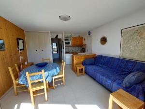 a living room with a blue couch and a table at Appartement cosy à Méaudre - 2 chambres, 5 pers, parking, lave-linge - FR-1-737-39 in Méaudre
