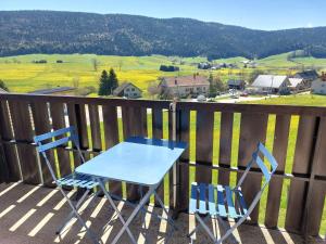 a blue table and chairs on a balcony with a view at Appartement cosy à Méaudre - 2 chambres, 5 pers, parking, lave-linge - FR-1-737-39 in Méaudre +4 photos
