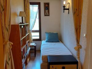 une petite pièce avec un lit et une fenêtre dans l'établissement Charmant appartement à Autrans, 3 pers, ski alpin/fond, balcon, parking, 200m du centre - FR-1-737-45, à Autrans