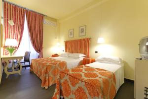 a hotel room with two beds and a desk at Relais Lavagnini Florence in Florence