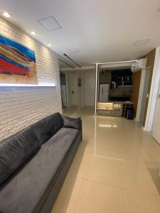 a living room with a couch and a brick wall at Apto VISTA MAR na Av Contorno in Salvador