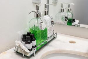 a bathroom sink with bottles on a shelf next to a mirror at Happy Sweet Home 3 in Sao Paulo