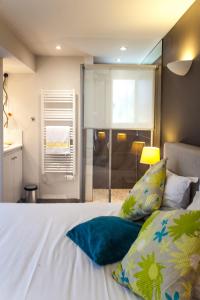 um quarto com uma cama branca e uma janela em Studio des Musiciens - quartier Orangerie em Estrasburgo