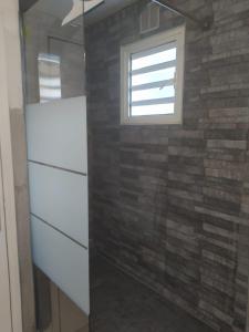聖丹尼斯的住宿－Appartement t3 rdc，浴室设有窗户和砖墙