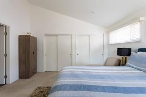 Luxurious 4Bdrm Home with Private Backyard near SOFI, LAX في إنجلوود: غرفة نوم بيضاء بسرير ازرق وبيض