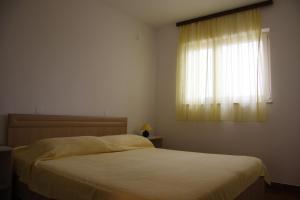 a bedroom with a bed and a window at Guest House Cattonaro in Šilo