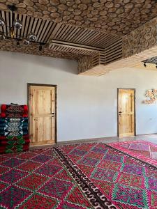 um quarto vazio com duas portas e um tapete em Kezgin Guest House em Naryn