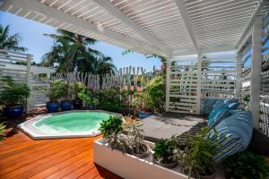 a patio with a hot tub and potted plants at Hôtel Le Lagon in Noumea