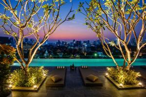 Blick auf die Stadt in der Nacht mit Bäumen und Lichtern in der Unterkunft GLOW PARK HOTEL Grand Royal Palace in Phnom Penh