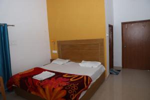 una camera con letto e testiera in legno di Hello India home stay a Khajurāho