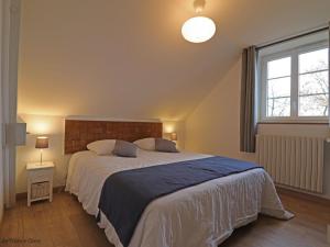 a bedroom with a large bed and a window at Gîte confortable avec animaux, jardin et wifi inclus, cadre paisible en Normandie - FR-1-497-6 in Céaucé
