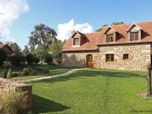 a large stone house with a grass yard at Gîte confortable avec animaux, jardin et wifi inclus, cadre paisible en Normandie - FR-1-497-6 in Céaucé