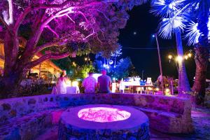 a group of people standing around a fire pit at night at Devi Kampot Resort at Phum Kampot in Kampot