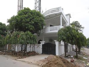 a white house with trees in front of it at Flagship Greenview Near Munshi Pulia Metro Station in Vibhuti Khand