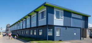 a blue building with people standing outside of it at The Ocean Front at Seaside in Seaside