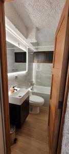y baño con aseo blanco y lavamanos. en Ski in-out Apartment in El Colorado en El Colorado