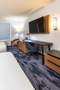 a hotel room with a desk and a bed at Fairfield Inn & Suites Rapid City in Rapid City