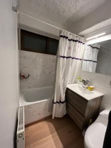 a bathroom with a sink and a shower curtain at Ski in-out Apartment in El Colorado in El Colorado