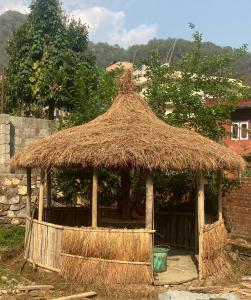 una cabaña con techo de paja y un edificio de ladrillo en Prashiddha Resort, en Dakshīnkāli