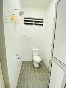 a white bathroom with a toilet and a shower at Homestay D Twinz (2 unit semi d) in Kuala Berang