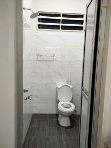 a white bathroom with a toilet and a window at Homestay D Twinz (2 unit semi d) in Kuala Berang