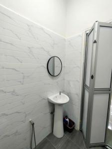 a white bathroom with a sink and a mirror at Homestay D Twinz (2 unit semi d) in Kuala Berang