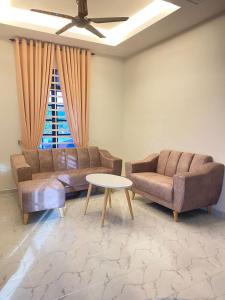 a living room with two couches and a table at Homestay D Twinz (2 unit semi d) in Kuala Berang