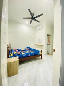 a bedroom with a bed with a ceiling fan at Homestay D Twinz (2 unit semi d) in Kuala Berang