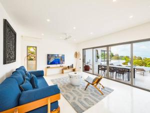 un salon avec un canapé bleu et une salle à manger dans l'établissement Villa Dila 3 bed Elephant Haven!, à Koh Samui 