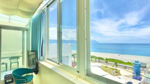 a room with a window looking out at the beach at Go to Qixingtan Seaview B&B in Dahan
