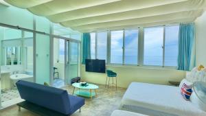 una camera con letto, divano e TV di Go to Qixingtan Seaview B&B a Dahan