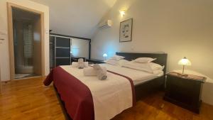 una camera da letto con un letto grande con lenzuola bianche di Old stone house VICKO a Podgora