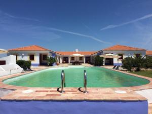 a large swimming pool in front of a house at Refúgio do Monte in Odemira