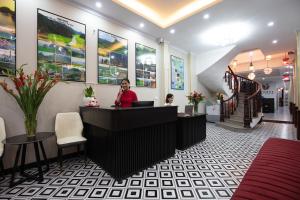 a woman standing at a counter in a lobby at Hanoi Liliane Hotel and Travel in Hanoi