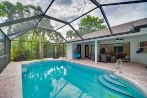 uma piscina interior com telhado de vidro e uma casa em Casa Blanco Florida Escape Pool, Fire Pit and Grill em Sebastian