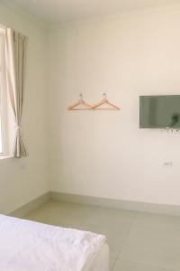 a white room with a bed and a window at TETE Homestay in Xiaoliuqiu
