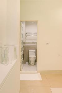 bagno con servizi igienici in una camera bianca. di TETE Homestay a Xiaoliuqiu
