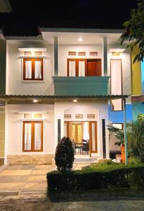 een wit huis met een veranda 's nachts bij Vila Kusuma Estate Batu in Batu