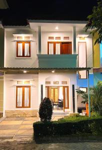 a white house with a front porch at night at Vila Kusuma Estate Batu in Batu