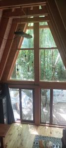 an attic room with large windows in a house at Casa Aurora in Puerto Fuy