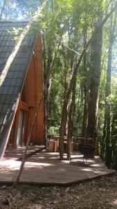eine Hütte im Wald mit einer Terrasse und Bäumen in der Unterkunft Casa Aurora in Puerto Fuy